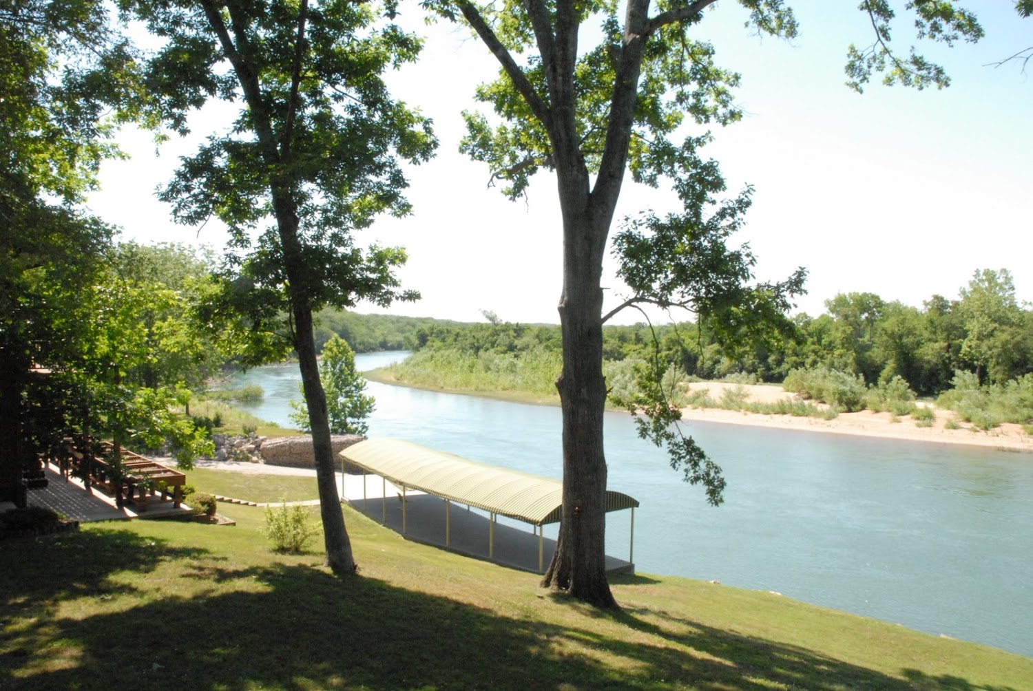 Archival water-side view of 251 Walleye Lane showing private boat ramp and pavilion canopy on the Current River